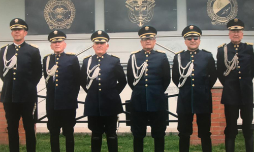 Oficiales del Grupo GOCAR uniformados frente a insignias institucionales